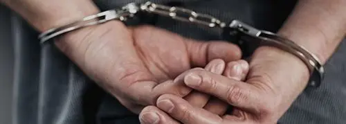 A person is holding their hands in chains.