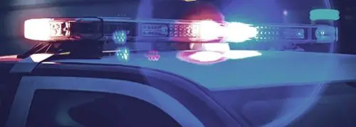 A police car lights up at night.